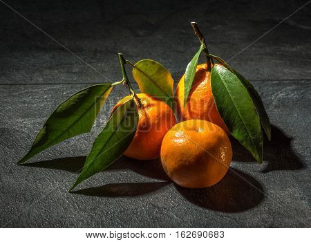 Delicious and rich in vitamins tangarines on a dark table