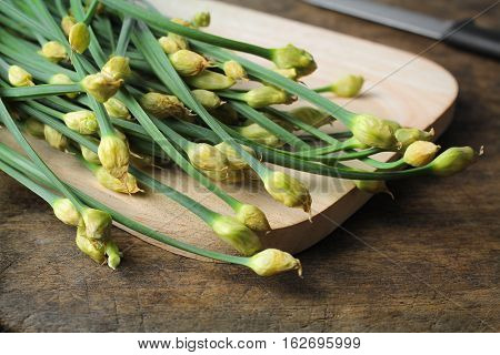 bunch of fresh chives on a wooden cutting board