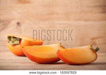 Ripe fresh persimmon on wood board. Food ingredient. Fruits.
