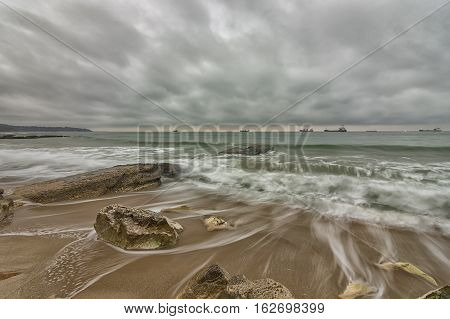 Beauty cloudy long exposure seascape with slow shutter and waves flowing out.