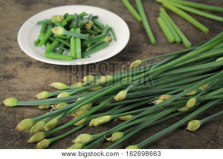 bunch of fresh chives on a wooden cutting board