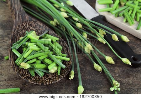 bunch of fresh chives on a wooden cutting board