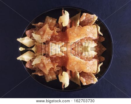 Crispy wonton in bowl isolated on black background