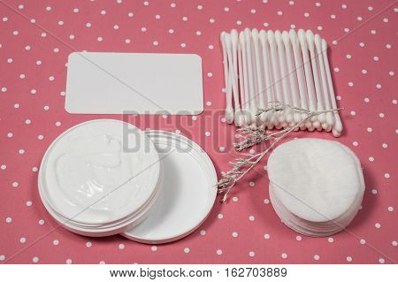 facials skin care. cotton pads and buds on the pink backgroung