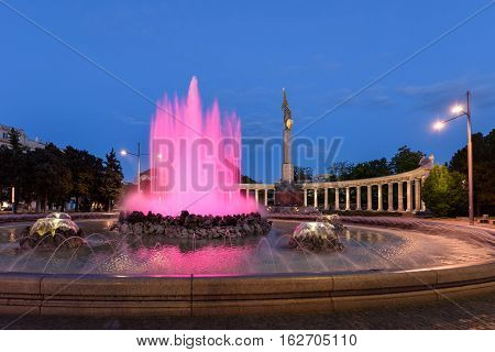 The heroes monument of the red army in schwarzenbergplatz at night with pink light fountain in vienna, austria