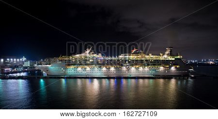 San Juan Puerto Rico - November 16 2015: Royal Cribbean cruise line ship Grandeur of the Seas standing in harbor with full bright illumination at night on water