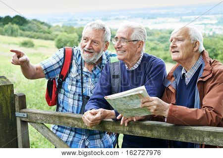 Group Of Senior Male Friends Hiking In Countryside
