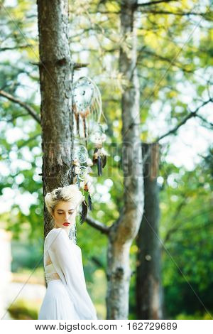 Outdoor portrait of a beautiful model girl with dream catcher vintage and retro tone, soft focus. Full red lips.