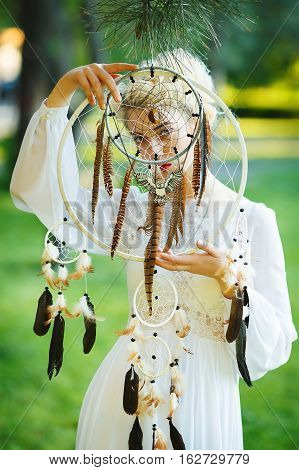 Outdoor portrait of a beautiful model girl with dream catcher vintage and retro tone, soft focus. Full red lips.