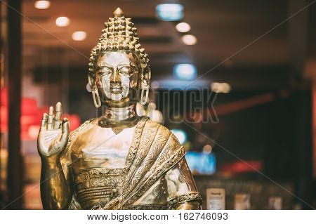 Golden Statue Of Buddha Sitting In Lotus Position With Raised Right Arm Gesture Showing Dispute, Explaining Teachings Of Buddha Vitarka Mudra.