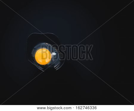 natural yellow egg on black background and cholesterol