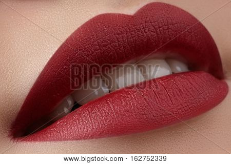 Close-up of woman's lips with fashion red make-up. Beautiful female mouth full lips with perfect makeup. Classic visage. Part of female face. Macro shot of beautiful make up on full lips.