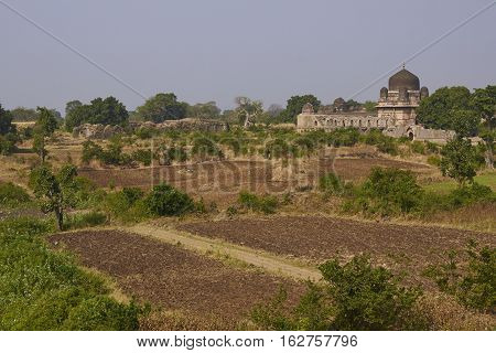 MANDU, MADHYA PRADESH, INDIA - NOVEMBER 18, 2008: Darya Khan's tomb in the hilltop fortress of Mandu. Building with central dome and a smaller dome on each corner in a walled compound. 16th Century AD