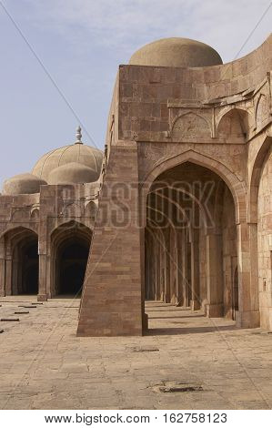 MANDU, MADHYA PRADESH, INDIA - NOVEMBER 18, 2008: Inner courtyard and covered prayer hall of the ancient mosque of Ashrafi Mahal Mosque in the hilltop fortress of Mandu in Madya Pradesh, India. 15th Century AD