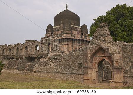 MANDU, MADHYA PRADESH, INDIA - NOVEMBER 18, 2008: Darya Khan's tomb in the hilltop fortress of Mandu. Building with central dome and a smaller dome on each corner in a walled compound. 16th Century AD