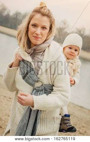 Young Mother Having Her Little Daughter In Baby Carrier Scarf