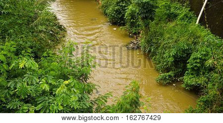A brown coloured dirty river in Bogor indonesia java