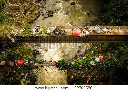 A dirty river flow with plastic waste photo taken in Bogor Indonesia java