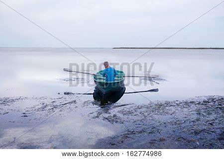 Man Sailing On A Small Rowing Boat Along The Sea Coast