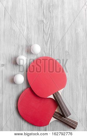 Red racket for ping pong ball on gray wooden background top view