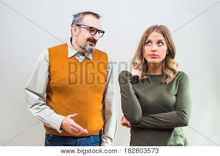 Nerdy man is trying to get beautiful woman's attention but she is not interested and angry ignore him.