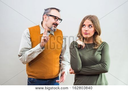Nerdy man is trying to get beautiful woman's attention but she is not interested and angry ignore him.