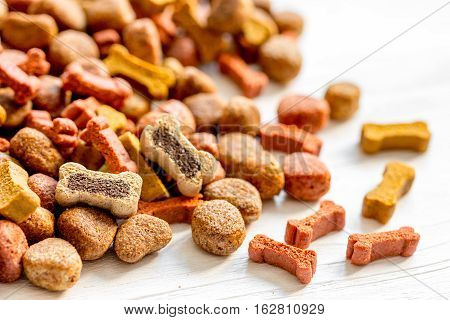 dry dog food in bulk on wooden background close up.