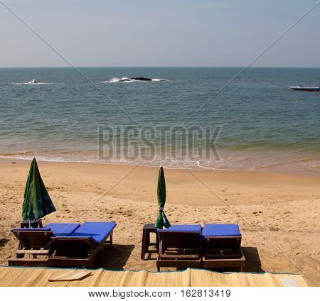 Pairs of blue sunbeds outside a restaurant on a sunny day at the Anjuna beach in Goa, India