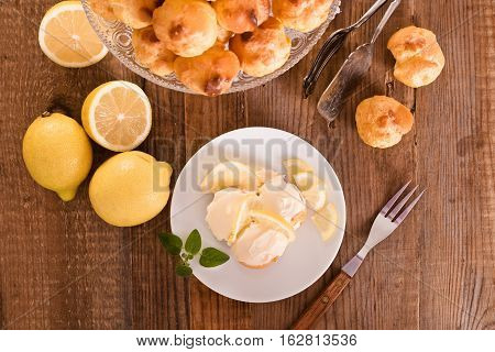 Lemon Profiteroles with lemon fruit on wooden table.