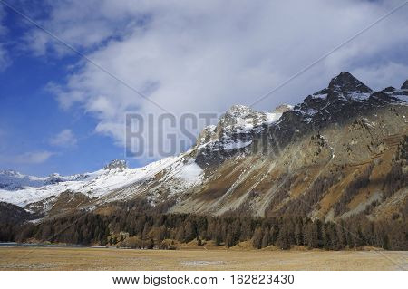 amazing landscape scenic view of Engadin valley in Switzerland Sils Maria village with snow on Alp mountains and frozen lake on a cold sunny winter day in tourism and holiday destination