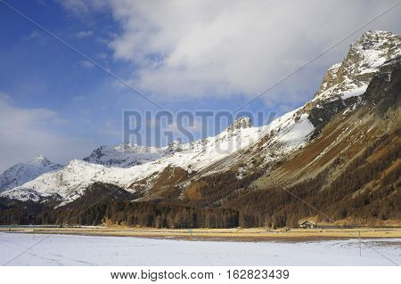 amazing landscape scenic view of Engadin valley in Switzerland Sils Maria village with snow on Alp mountains and frozen lake on a cold sunny winter day in tourism and holiday destination