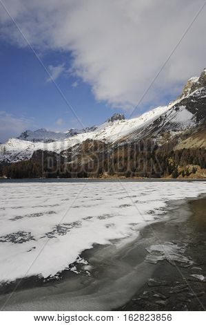 amazing landscape scenic view of Engadin valley in Switzerland Sils Maria village with snow on Alp mountains and frozen lake on a cold sunny winter day in tourism and holiday destination