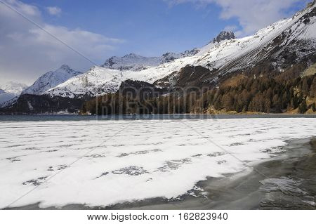 amazing landscape scenic view of Engadin valley in Switzerland Sils Maria village with snow on Alp mountains and frozen lake on a cold sunny winter day in tourism and holiday destination
