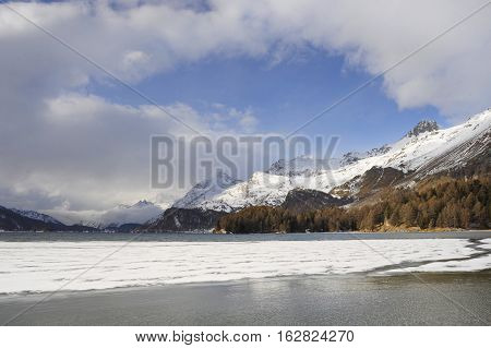 amazing landscape scenic view of Engadin valley in Switzerland Sils Maria village with snow on Alp mountains and frozen lake on a cold sunny winter day in tourism and holiday destination