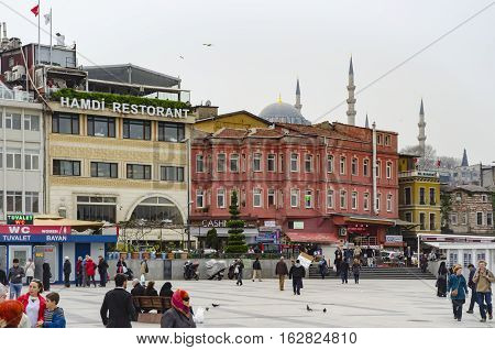 Istanbul Turkey - March 29 2013: Around the buildings the historic mosque and the people traveling with the Eminonu square