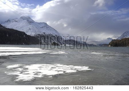 amazing landscape scenic view of Engadin valley in Switzerland Sils Maria village with snow on Alp mountains and frozen lake on a cold sunny winter day in tourism and holiday destination