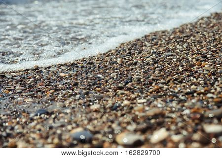 Close up of a pebble beach with a sea.