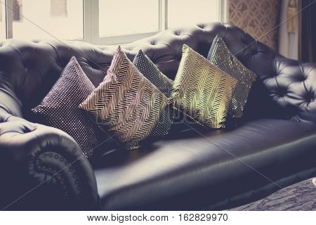 black leather sofa in luxurious interior room vintage filter selective focus.