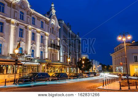 Vilnius, Lithuania - July 8, 2016: Side View Of Facade Of Radisson Blu Royal Astorija Hotel On Illuminated Didzioji Street With Motion Blur Effect In Old Town Under Summer Evening Blue Sky