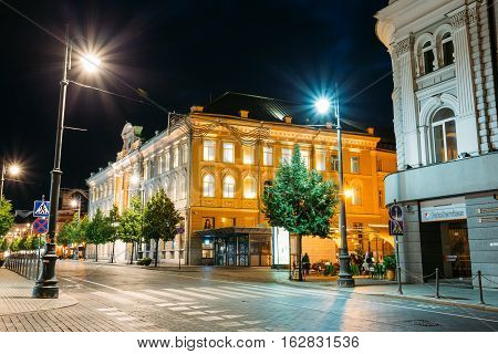 Vilnius, Lithuania - July 8, 2016: The Facades Of Ancient Buildings In Bright Evening Illumination On Deserted Gediminas Avenue, The Main City Street, Famous Landmark Under Dark Black Sky.