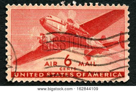 UNITED STATES OF AMERICA - CIRCA 1943: A used US Air Mail postage stamp depicting an illustration of a vintage transport plane circa 1943.