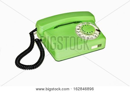 On a white background is an old telephone with a rotary dialer