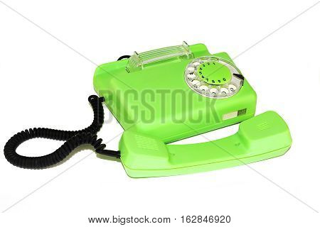 On a white background is an old telephone with a round dialer
