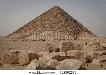 Old pyramid in the desert with stones in front of it