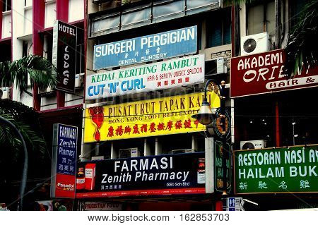 Kuala Lumpur Malaysia - January 3 2008: Business signs cover building facades for pharamcies restaurants hotels and hair salons on Bukit Bintang Walk