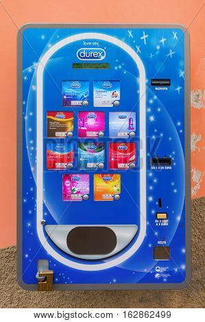 Riomaggiore Italy - July 02 2016: condom machine at a wall. Condom machines are often placed in public toilets subway stations airports or schools as a public health measure to promote safe sex.