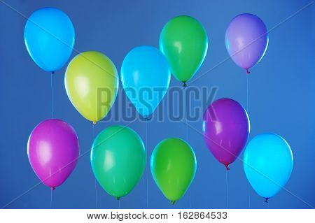 Colorful balloons arranged in two rows on dark blue background