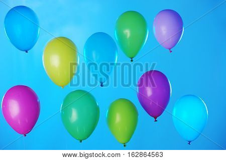Colorful balloons arranged in two rows on dark blue sky