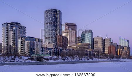 CALGARY, CANADA - DEC 17: Calgary's skyline at sunrise on a cold winter day on December 17, 2016 in Calgary, Alberta. Calgary is home to many oil companies. The Bow River is visible.