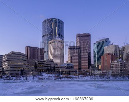 CALGARY, CANADA - DEC 17: Calgary's skyline at sunrise on a cold winter day on December 17, 2016 in Calgary, Alberta. Calgary is home to many oil companies. The Bow River is visible.